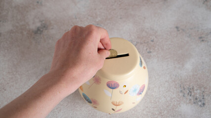 Save money. Hand putting a penny in a piggy bank. Grandma's piggy bank to save money. Money Coin Saving. 