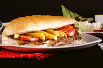 A delicious doner donair kebab in bread with spicy meat, lettuce, tomato, red onion and sauce.