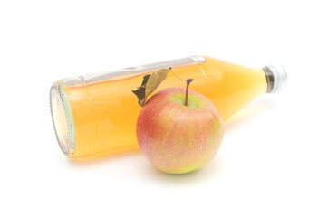 One whole apple with leaf and a lying bottle of apple cider vinegar isolated on white background.