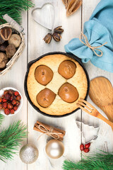 Christmas background with a pie with pears, Christmas toys and a blue napkin. Top view, vertical orientation. The concept of New year and Christmas.