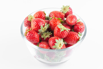 Fresh strawberry in a transparent bowl isolated on white background, top view