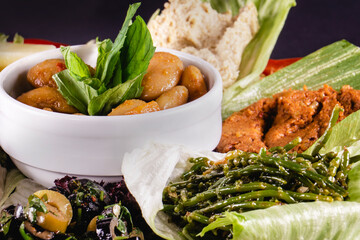 Middle Eastern meze platter with green falafel, pita, sun dried tomatoes, pumpkin and beet hummus.Mediterranean appetizer party idea