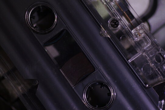 Audio cassette - in a dark light, against the background of a tape recorder.