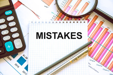  the word error is written on a white piece of paper with a calculator, pen, color charts. mistakes...