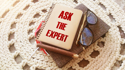 Ask an expert on the cover of notebook. business concept