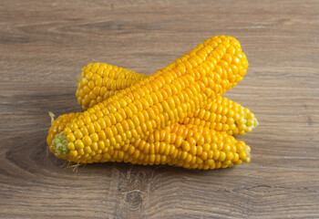 Corn lies on canvas. A new crop. Corn cob on a plate. Sweet corn on background for food ingredients and cooking concept.