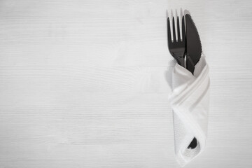 cutlery fork and knife plastic black on a white background wrapped in a napkin