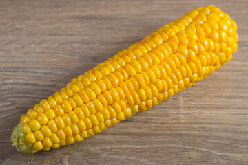 Corn lies on canvas. Fresh corn closeup. Corn cob on a plate. Sweet corn on background for food ingredients and cooking concept.