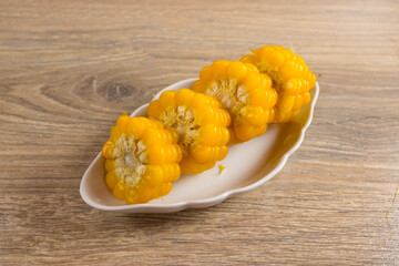 Corn lies on canvas. Fresh corn closeup. Corn cob on a plate. Sweet corn on background for food ingredients and cooking concept.