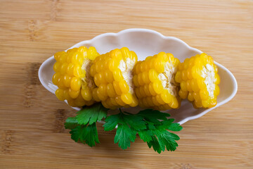 Corn lies on canvas. Fresh corn closeup. Corn cob on a plate. Sweet corn on background for food ingredients and cooking concept.