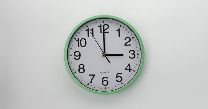 Quartz wall clock on a white background. The clock shows three o'clock. 4K DCI video. 
