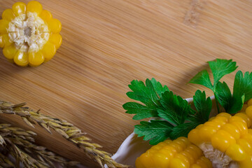 Corn lies on canvas. Fresh corn closeup. Corn cob on a plate. Sweet corn on background for food ingredients and cooking concept.