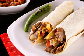 A delicious doner donair kebab wrap with spicy meat, lettuce, tomato, red onion and sauce.