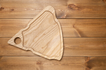 Wooden plate for cheese on wood boards table, top view.