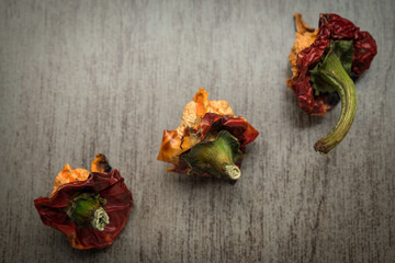Damaged red peppers on a wooden table at home 