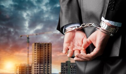 Male hands in handcuffs behind his back