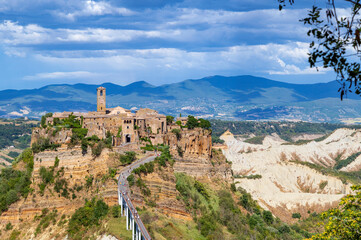 Picturesque panoramic view of Civita di Bagnoregio, the medieval town surrounded by clouds. The village on the top a plateau of volcanic tuff known as The Dying Town, Viterbo provence, Lazio, Italy.