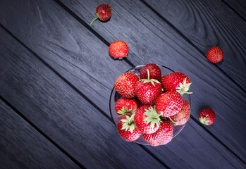 Fresh red strawberries on a dark wood background. Place for text