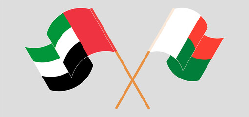 Crossed and waving flags of Madagascar and the United Arab Emirates