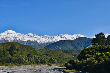 Naklejka na ściany i meble View of South Island New Zealand Mountains Covered with Snow and Foothills and River Bed