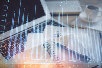 Double exposure of financial chart drawing and desktop with coffee and items on table background. Concept of forex market trading