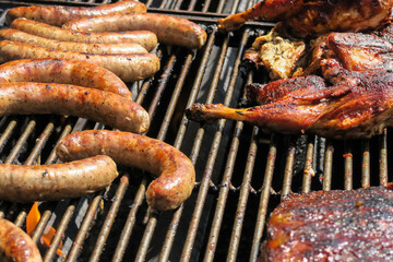 Barbecue with sausage and chicken legs on a grill