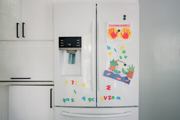 fridge with magnets and child artwork