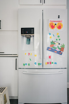 Refrigerator With Letter Magnets And Kid Artwork