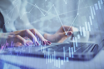 Multi exposure of woman hands typing on computer and financial graph hologram drawing. Stock market analysis concept.