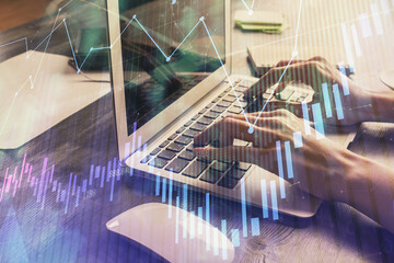 Double exposure of woman hands typing on computer and forex chart hologram drawing. Stock market invest concept.