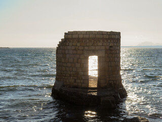 Sunshine passing through the window of a ruin tower in the Mediterranean sea in Antibes (France)