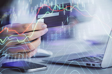 Multi exposure of woman on-line shopping holding a credit card and financial graph drawing. Stock market E-commerce concept.