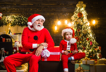 Fototapeta na wymiar Santa with little helper. Christmas time. New Year holidays. Winter. Presents. Christmas and new year concept. Santa Claus. Letters for Santa.