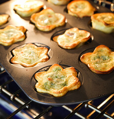 Flower Shaped Quiches in Baking Pan in Oven on Rack