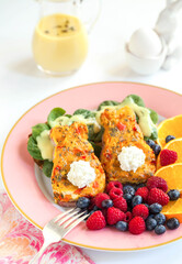 Bunny Shaped Eggs Benedict for Easter Spring Brunch with Raspberries, Oranges, Blueberries on Pink Plate with Hollandaise Sauce in Glass Pitcher with Egg in Bunny Egg Cup