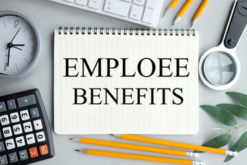 emploee benefits, text on notebook on gray background near magnifier, pencils, plant, keyboard