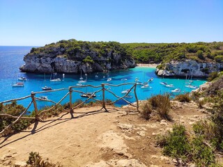 Fototapeta premium Scenic viewpoint (mirador) of Cala Macarelleta famous paradise beach with turquoise water and pine forests on south coast of Menorca Island, Balearic Islands, Spain.