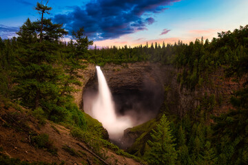 Beautiful View of a waterfall, Helmcken Falls, in the Canadian Mountain Landscape. Taken in Wells Gray Provincial Park, near Clearwater, BC, Canada. Colorful Sunset Artistic Render