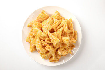 Crisp corn snack in white plate isolated on white background. top view