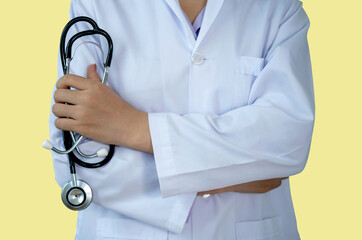 Doctor holding stethoscope and arms folded against, Isolate on yellow background