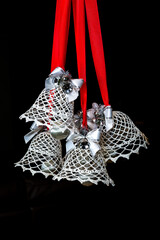 Crochet white christmas bells on black background portrait orientation 