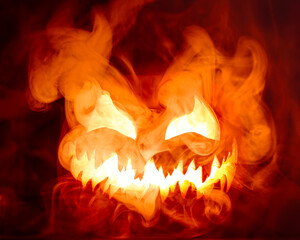 Fiery red hot Halloween jack o lantern pumpkin carved with scary evil face glowing brightly with...