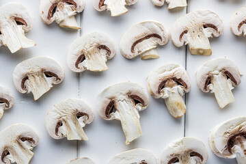 Fresh mushrooms champignon on a white wooden board.