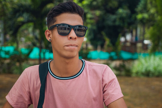 Portrait of cheerful young man wearing sunglasses in park