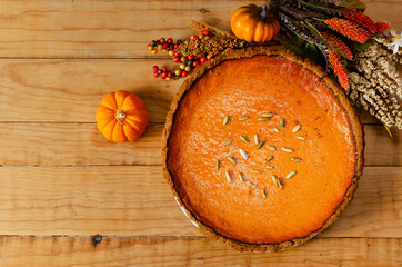 Hermoso pay de calabaza sobre mesa de madera.