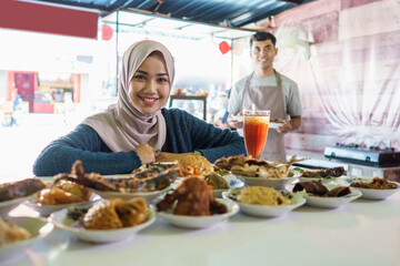 a portrait of a woman who is about to eat a dish of padang food