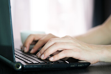A computer worker. He is typing text on the computer keyboard. And working at home, technology concept