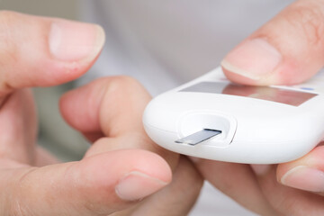 hand of people check diabetes and high blood glucose monitor with digital pressure gauge. Healthcare and Medical concept