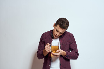 Drunk man with a mug of beer vacation alcohol lifestyle in a red shirt emotions light background