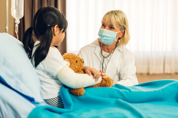 Smiling woman doctor service help support discussing and consulting talk to little girl patient give teddy bear and check up information in hospital